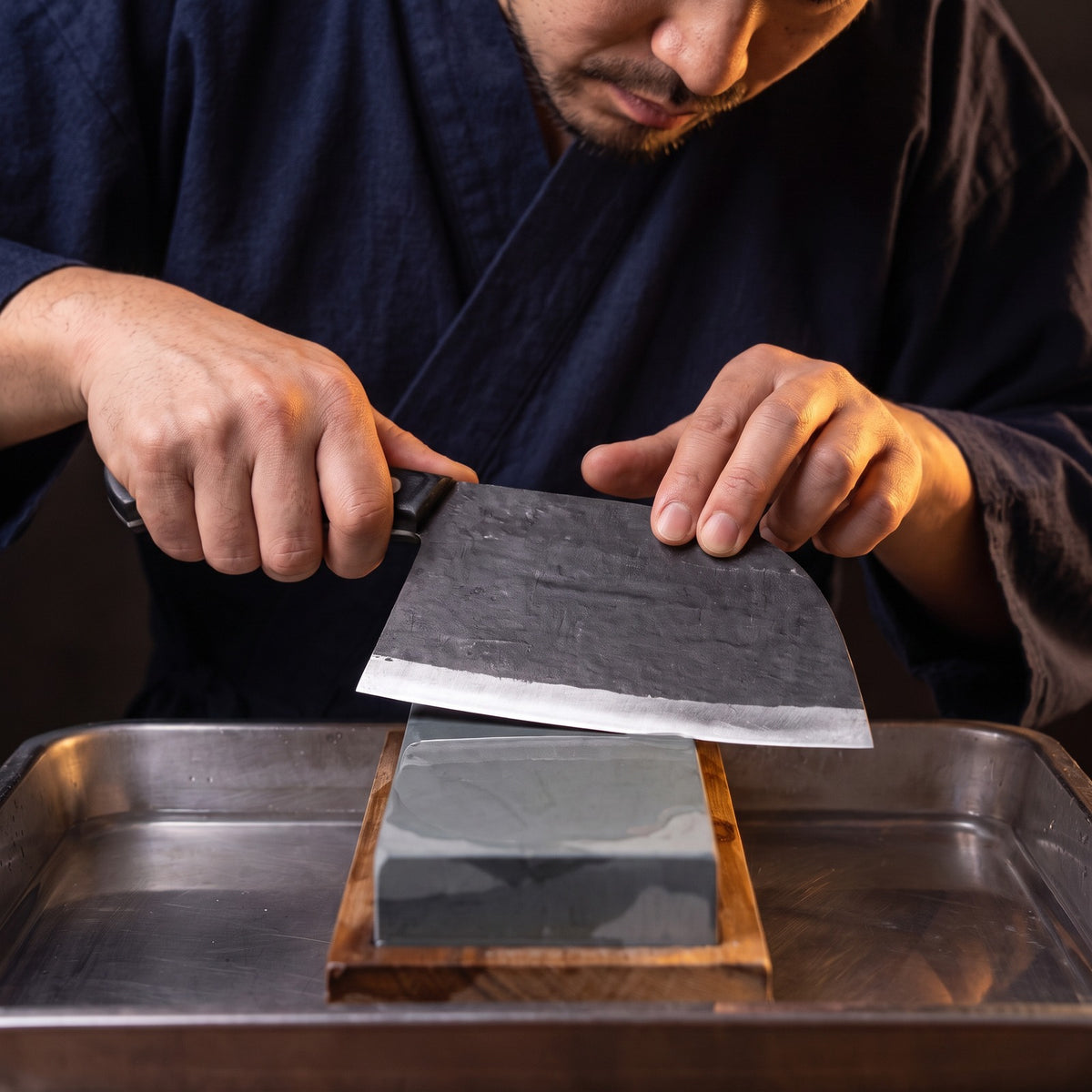 Hatori Kaji 鍛冶 Series – Black Forged Cleaver 17.5 cm, on the whetstone